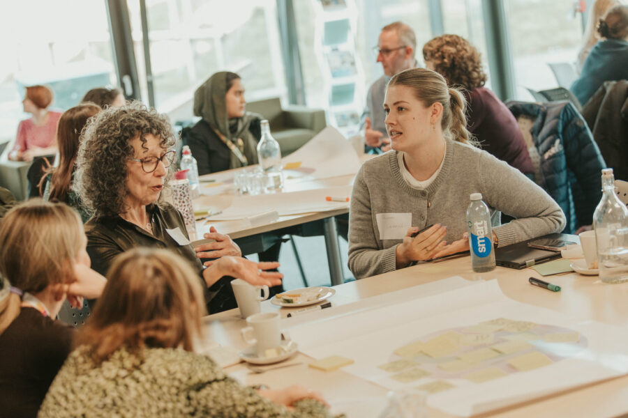 A group of women working together at the table, discussing, and collaborating